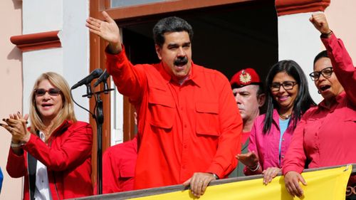 Venezuela's President Nicolas Maduro, centre, addresses leftist red shirt supporters on the balcony of the presidential palace.