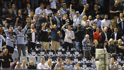 Prime Minister Scott Morrison cheers as the Cronulla Sharks score a try.