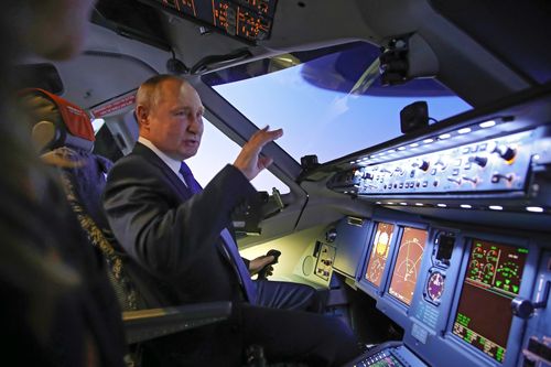 Russian President Vladimir Putin sits in the cockpit of an airplane simulator as he visits to Aeroflot Aviation School outside Moscow, Russia, Saturday, March 5, 2022 