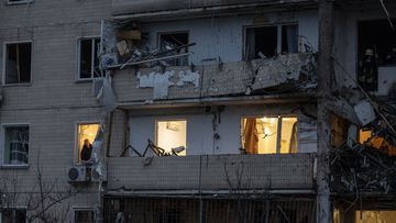 A man inspects the damage at a building following a rocket attack on the city of Kyiv.