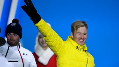 Jarryd Hughes of Australia gestures prior to receiving the silver medal for Snowboard Cross during a medal ceremony. (AAP)