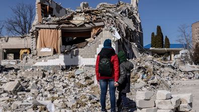 Oamenii se uită la pagubele la o școală care a fost lovită de un atac rusesc în urmă cu zece zile, pe 20 martie 2022, în Jytomyr, Ucraina.  Forțele ruse rămân la periferia capitalei ucrainene, dar avansul lor s-a blocat în ultimele zile, chiar dacă loviturile rusești - și bucăți de rachete interceptate - au lovit zonele rezidențiale din nordul Kievului.  Se estimează că jumătate din populația Kievului a fugit în alte părți ale țării sau în străinătate, de când Rusia a invadat.