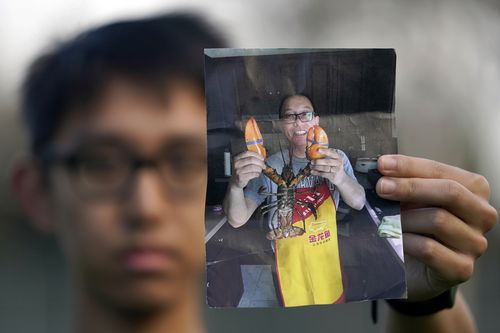 Harrison Li holds a photo of his father Kai Li, 