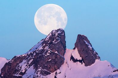 A view of the supermoon in the sky over the Les Jumelles Mountains in Plambuit, Switzerland.