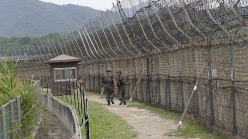 Żołnierze armii Korei Południowej patrolują, gdy turyści odwiedzają Szlak Pokoju w Strefie Zdemilitaryzowanej w strefie zdemilitaryzowanej w Goseong w Korei Południowej.