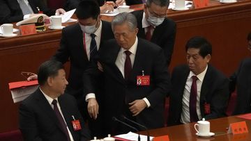 Former Chinese President Hu Jintao, centre, is helped during the closing ceremony of the 20th National Congress of China&#x27;s ruling Communist Party at the Great Hall of the People in Beijing, Saturday, Oct. 22, 2022.  