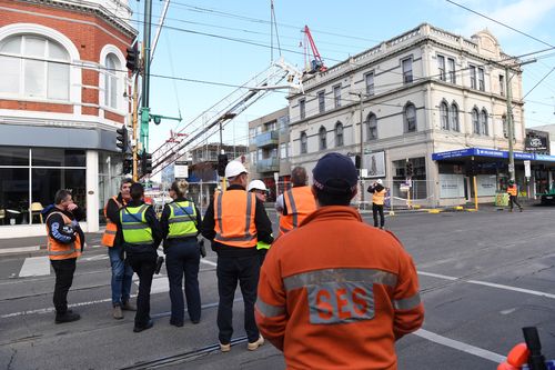 Part of the damaged crane was brought down by engineers this morning. Picture: AAP