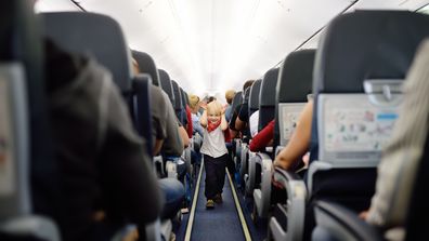 Happy little boy during traveling by an airplane. Traveling with kids. Family enjoying trip in aircraft. Transportation safety