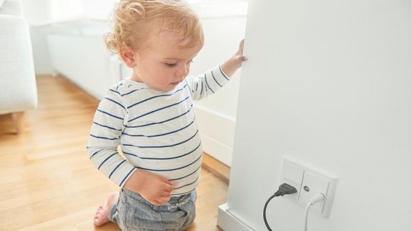 Toddler looking at powerplugs. 