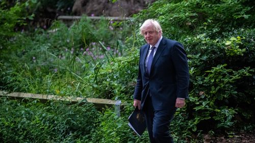 British Prime Minister Boris Johnson walks through Downing Street after attending a press conference.