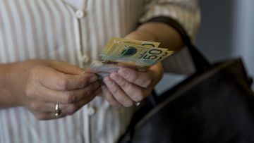 Woman holding Australian cash.