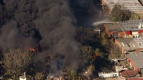 Black plumes of smoke rise from an out-of-control blaze near Penrith, in Sydney's West. (9NEWS)