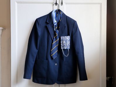 School uniform with face cover hanging up