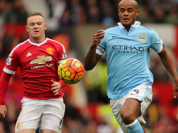 City's Vincent Kompany (R) leads Wayne Rooney to the ball. (Getty)
