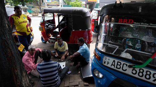 Sri Lankan auto-rickshaw drivers waiting to buy fuel amidst the financial crisis.