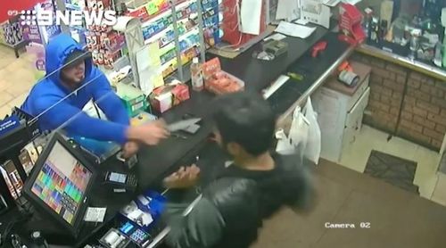 The thief lunges at the cashier after demanding cash. 