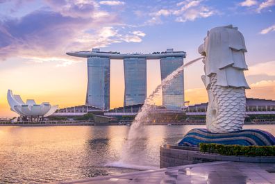 Silhouette of Merlion Statue at Marina Bay against the sunrise.