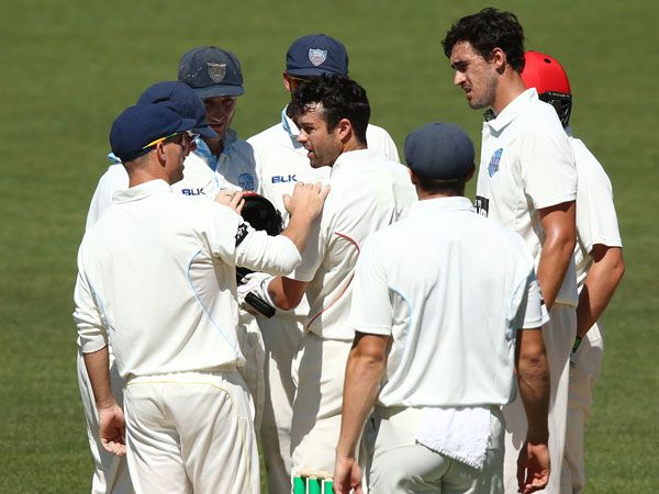 NSW players check on SA batsman Callum Ferguson after he was struck in the helmet by a Mitchell Starc bouncer. (Getty)