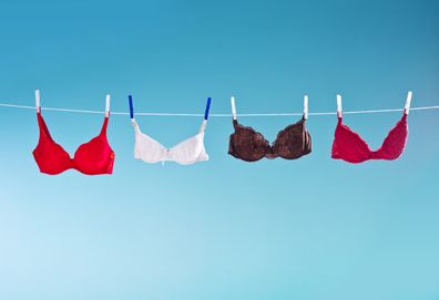 Colorful bras hanging against blue background