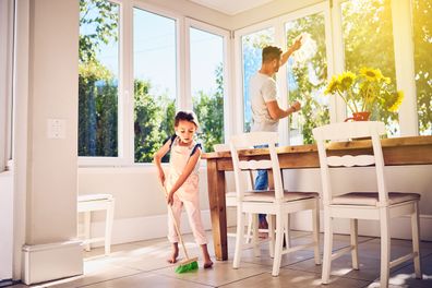 Shot of a father and his little daughter doing chores together at home