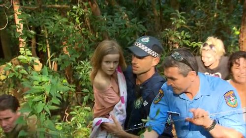 Police carry nine-year-old Natalya from the bush, 24 hours after she vanished. (9NEWS)