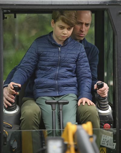 Prince William is helped by Prince George as he uses an excavator while taking part in the Big Help Out, during a visit to the 3rd Upton Scouts Hut in Slough, England, Monday, May 8, 2023 