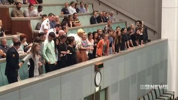 Protesters super-glue hands to public gallery railing during Question Time demonstration