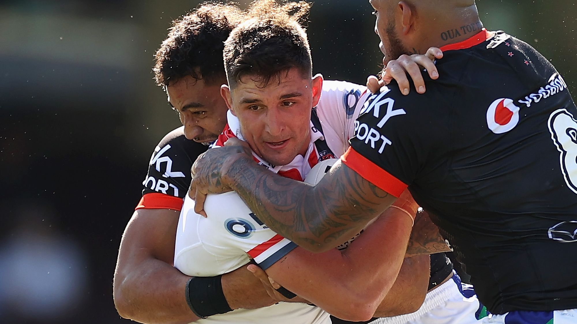 Victor Radley of the Roosters is tackled.