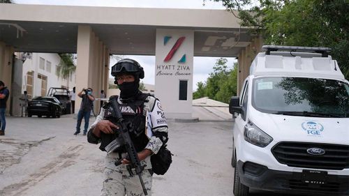 Fuerzas gubernamentales custodian la entrada al hotel luego de un enfrentamiento armado cerca de Puerto Morelos, México.