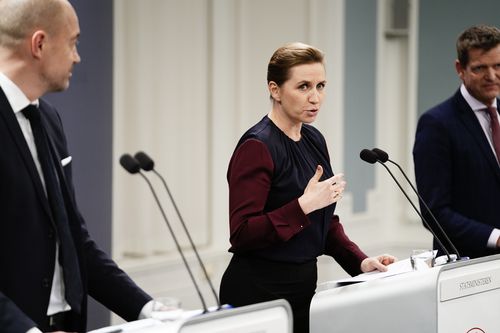 Denmark's Prime Minister Mette Frederiksen, takes part in a coronavirus press conference, with Minister of Health Magnus Heunicke, left, and director of the National Board of Health Soeren Brostroem, right, in Copenhagen, Denmark, Wednesday Jan. 26, 2022