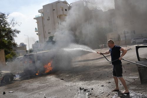 Cars are on fire after they were hit by rockets from the Gaza Strip in Ashkelon, Israel, on Saturday, Oct. 7, 2023. 