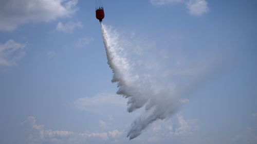 A firefighting aircraft drops water