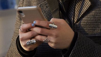 Woman using phone at train station