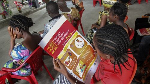A Liberian woman reads an Ebola information poster on the prevention of the Ebola epidemic. (AP)