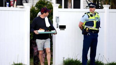 New Zealand Labour Party leader Jacinda Ardern's partner Clarke Gayford delivers home cooked food to the media waiting outside their house on October 17, 2020 in Auckland, New Zealand