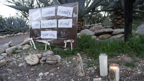 Acendeu velas ao lado de uma placa de vizinhos apoiando a família Guthrie do lado de fora da casa de Nancy Guthries nas primeiras horas da manhã de domingo, 8 de fevereiro de 2026 em Tucson, Arizona (AP Photo/Ty ONeil)