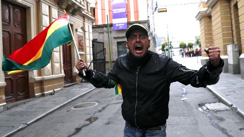 An opponent of Bolivia's President Evo Morales celebrates after he announced his resignation, in La Paz, Bolivia