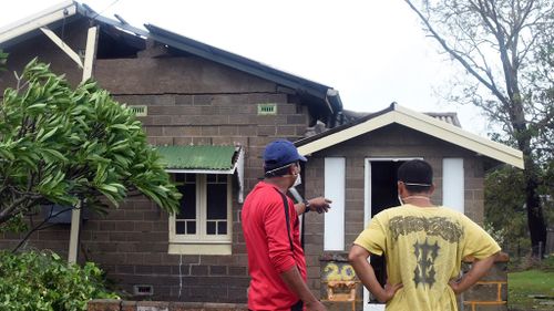 Mr Medil and a friend inspecting the damage to his home. (AAP)