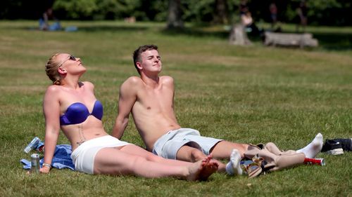 Sunbathers lie on the grass in Hyde Park, London. (AAP)