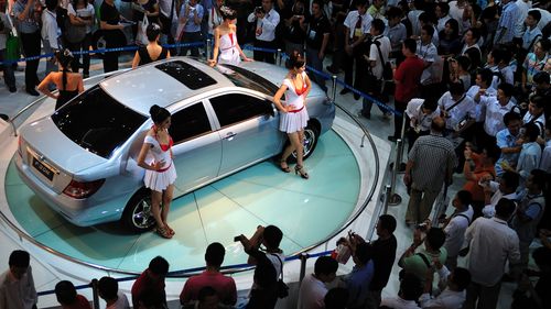 Les visiteurs d’un salon automobile regardent une voiture BYD 