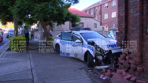 Two police officers have been hurt in Sydney after slamming their car into a building