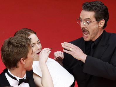 Emma Stone tries to avoid a bee next to Austin Butler and Pedro Pascal at the premiere of Eddington during the 78th annual Cannes Film Festival, in Cannes, France, 16 May 2025 