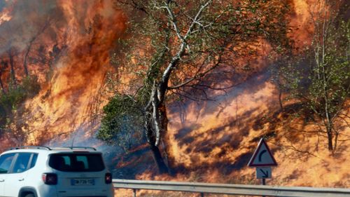 Fires burn on the side of the road in Vitrolles, north of Marseille. (AFP)