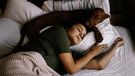 Woman and dog sleeping in same bed