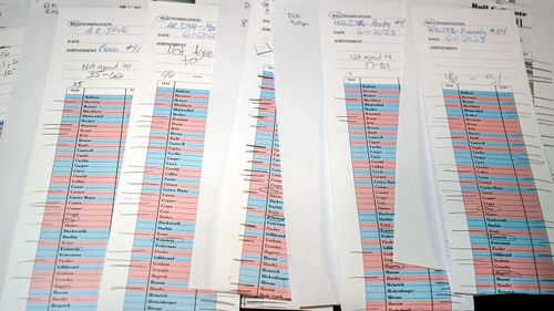 Voting tally sheets are seen in the press gallery after a hectic series of amendment votes and final passage on the big debt ceiling and budget cuts package.