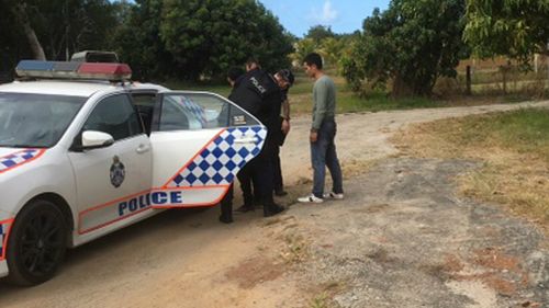 Two suspected asylum seekers being detained by police on the banks of the Daintree River after their fishing vessel sank in waters off the coast of Queensland. 