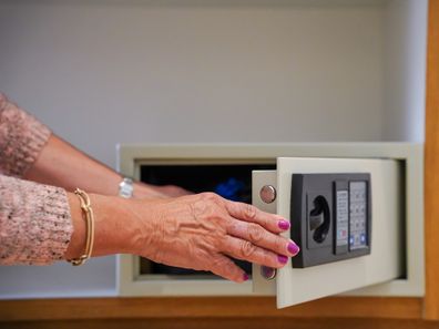 Unrecognizable woman opening the safe in a hotel