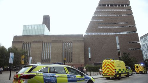 Emergency crews attending a scene at the Tate Modern art gallery, London, Sunday, Aug. 4, 2019. London police say a teenager was arrested after a child "fell from height" at the Tate Modern art gallery.