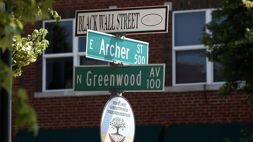 FILE - In this Monday, June 15, 2020, file photo, a sign marks the intersection of Greenwood Avenue and Archer Street, the former home of Black Wall Street, in Tulsa, Okla. Black community leaders in Tulsa said they fear a large rally by President Donald Trump in the city this weekend could spark violence, and the state's governor asked Trump not to visit the site of a race massacre where up to 300 black residents were killed by white mobs in 1921. (AP Photo/Sue Ogrocki)