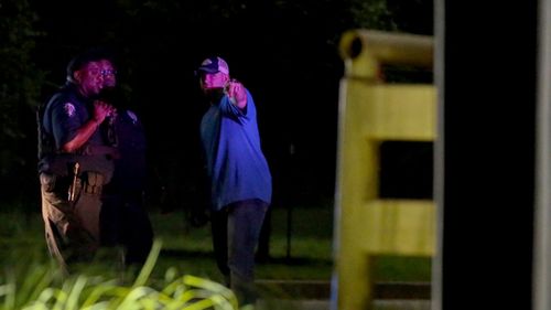 Police interview witnesses near the shooting scene. (AP).